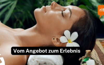 Frau liegt entspannt auf einer Wellnessliege, mit einer Orchideenblüte im Haar, in ruhiger Spa‑Atmosphäre.